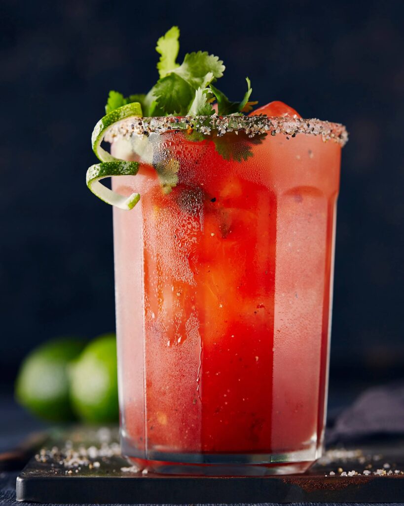caesar drink with lime spiral and parsley garnish